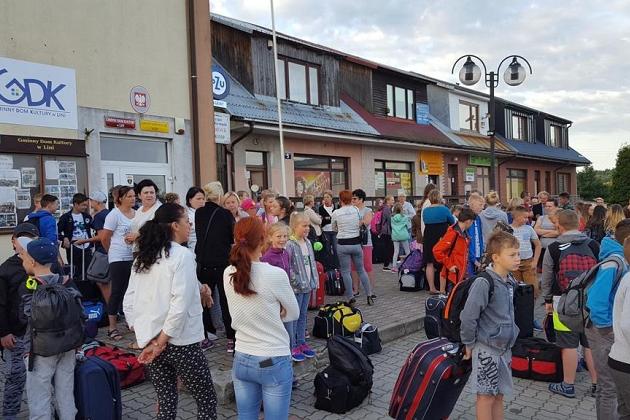 Uczestnicy językowej kolonii letniej w Karpaczu z bagażami przed budynkiem.