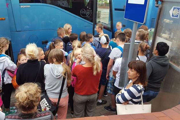 Grupa dzieci i dorosłych podczas aktywności na językowej kolonii letniej.