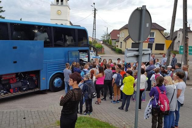 Uczestnicy kolonii w Karpaczu gotowi do odjazdu, stojący przy niebieskim autokarze.