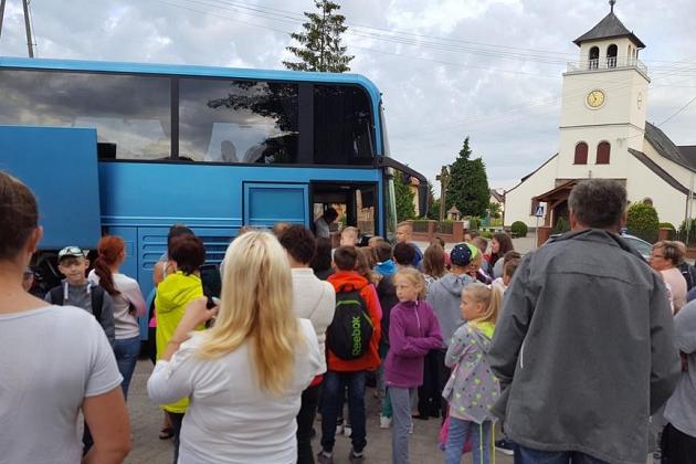 Uczestnicy kolonii językowych przy autokarze i kościele w Karpaczu.