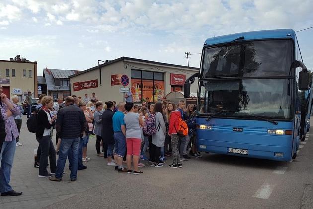 Uczestnicy językowej kolonii letniej w Karpaczu przed niebieskim autokarem.