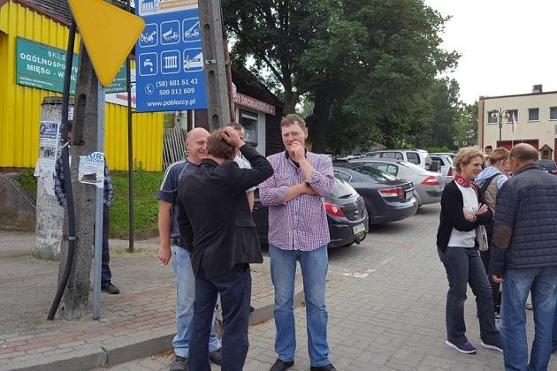 Uczestnicy kolonii językowej rozmawiają na chodniku w Karpaczu, otoczeni budynkami i samochodami.