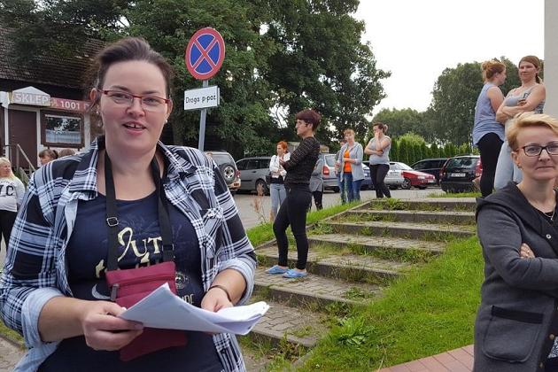 Uczestnicy kolonii językowej w Karpaczu, jedna osoba z uśmiechem trzyma dokumenty.
