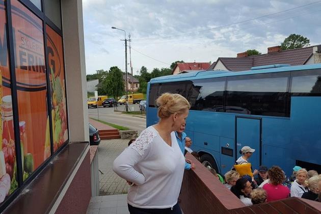Uczestniczka kolonii stoi na balkonie, w tle widać autobus i budynek w Karpaczu.
