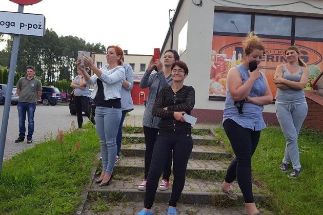 Grupa uczestników letniej kolonii językowej pozuje na schodach przed budynkiem.