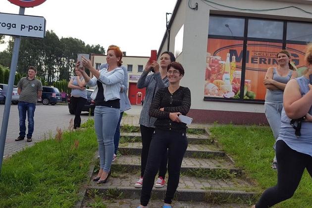Młodzi uczestnicy kolonii letniej pozują do zdjęcia przed budynkiem.