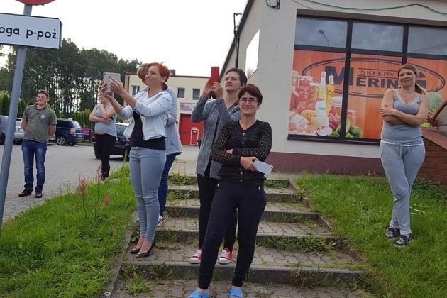 Uczestnicy kolonii językowej pozują na schodach budynku w słoneczny dzień.