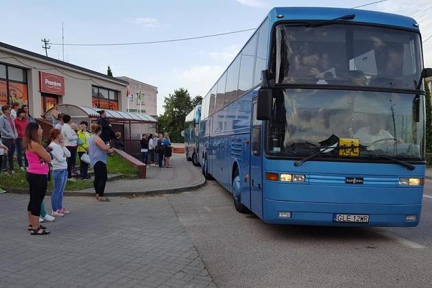 Grupa uczestników kolonii językowej w Karpaczu przy niebieskim piętrowym autokarze.