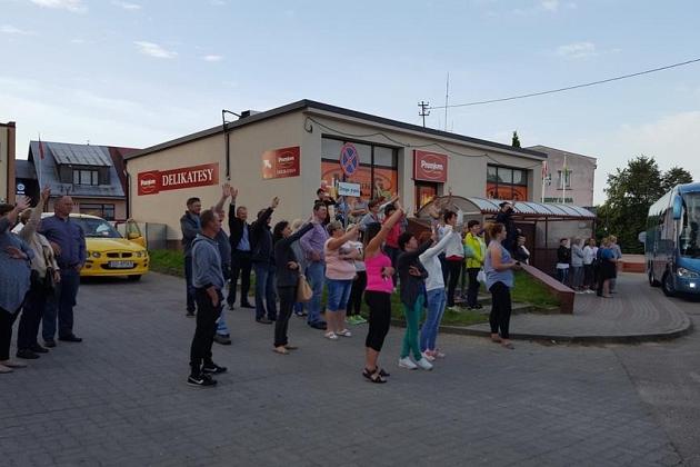 Uczestnicy kolonii w Karpaczu machają przed budynkiem, widać też autobus.