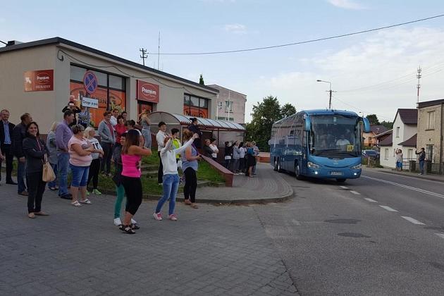 Koloniści z Karpacza gromadzą się obok niebieskiego autokaru.