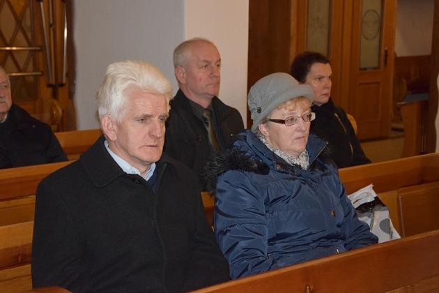 Uczestnicy świątecznego spotkania Gminnego Koła Pszczelarzy, siedzący w ławkach.