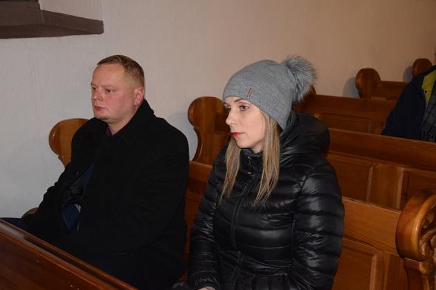 Mężczyzna i kobieta w zimowych ubraniach obecni na spotkaniu pszczelarzy.