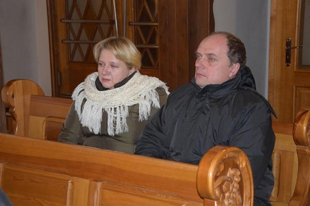 Kobieta i mężczyzna siedzą na drewnianej ławce podczas świątecznego spotkania.