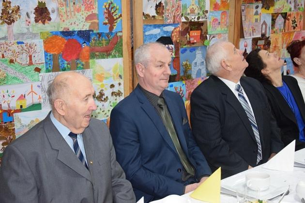 Mężczyźni na spotkaniu świątecznym Gminnego Koła Pszczelarzy siedzą przy stole.