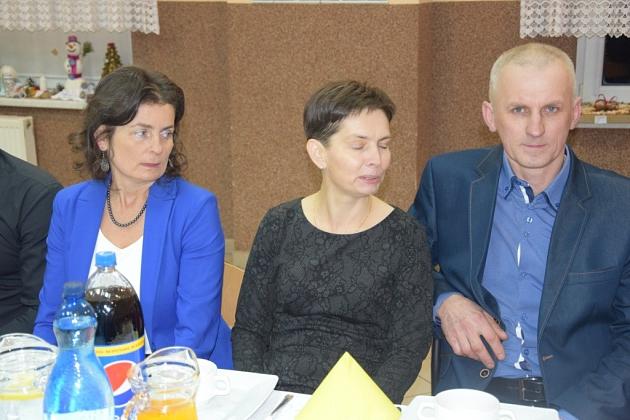 Uczestnicy świątecznego spotkania Gminnego Koła Pszczelarzy siedzący przy stole.