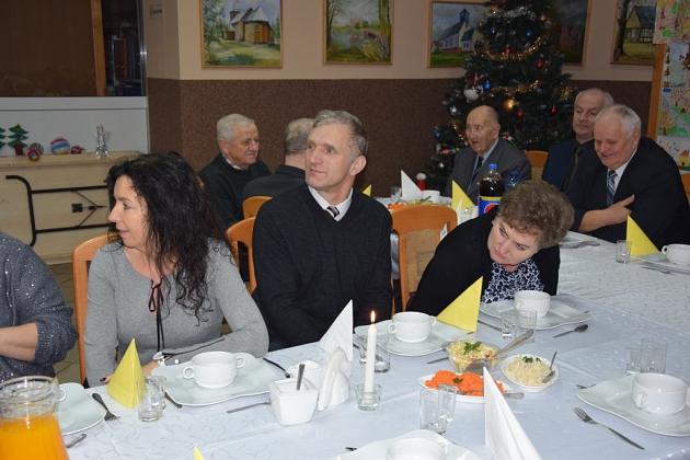 Grupa pszczelarzy przy stole podczas świątecznego spotkania.