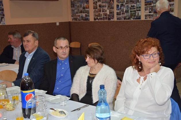 Członkowie Gminnego Koła Pszczelarzy przy stole podczas świątecznego spotkania.