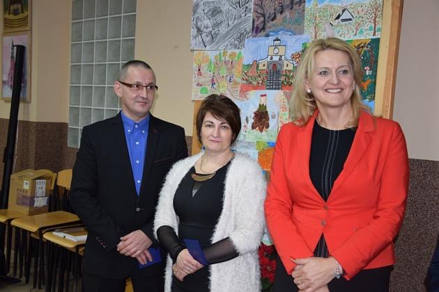 Trzech uczestników świątecznego spotkania pszczelarzy pozuje do pamiątkowego zdjęcia.