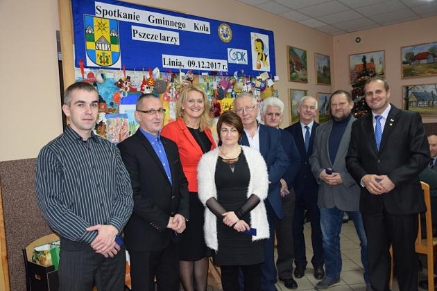 Członkowie Koła Pszczelarzy z Gminy Linia pozują na świątecznym spotkaniu.