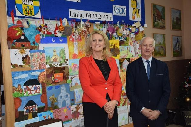 Kobieta i mężczyzna w strojach wizytowych na świątecznym spotkaniu pszczelarzy.