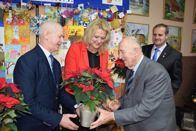 Świąteczna wymiana prezentu wśród pszczelarzy, kobieta w czerwonym uśmiecha się.