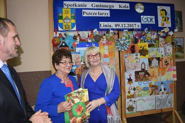 Wręczenie upominku dwóm kobietom na świątecznym spotkaniu Gminnego Koła Pszczelarzy.