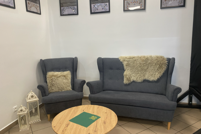 Wygodne fotele i sofa ze stolikiem tworzą przyjazną przestrzeń dla seniorów.